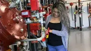 Woman closing valve at fire sprinkler riser